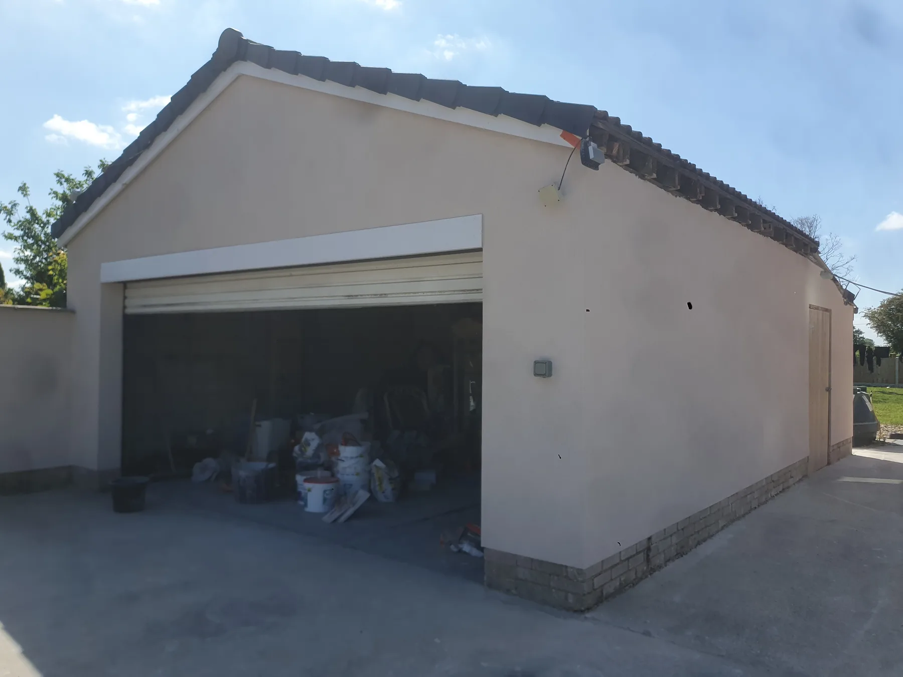 Detached garage rendered in warm cream silicone — gable end and side wall fully finished